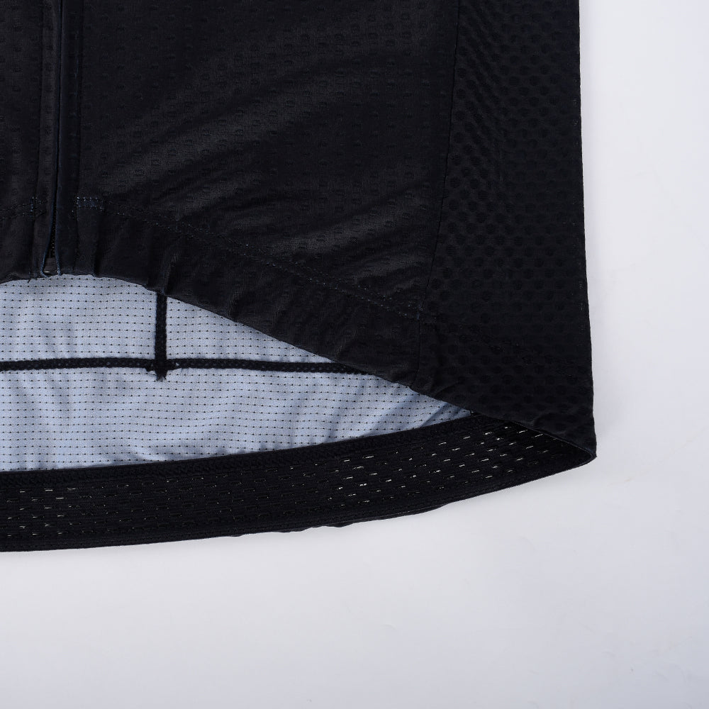 Close-up of C&C Tattoo Eagle Jersey hem. Black fabric with tonal dot pattern.