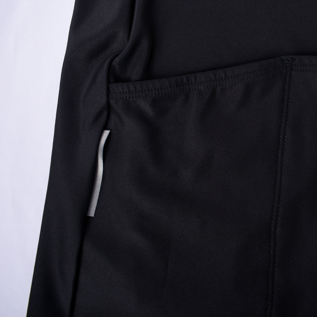 Close-up of black men's thermal jersey pocket with reflective strip detail.