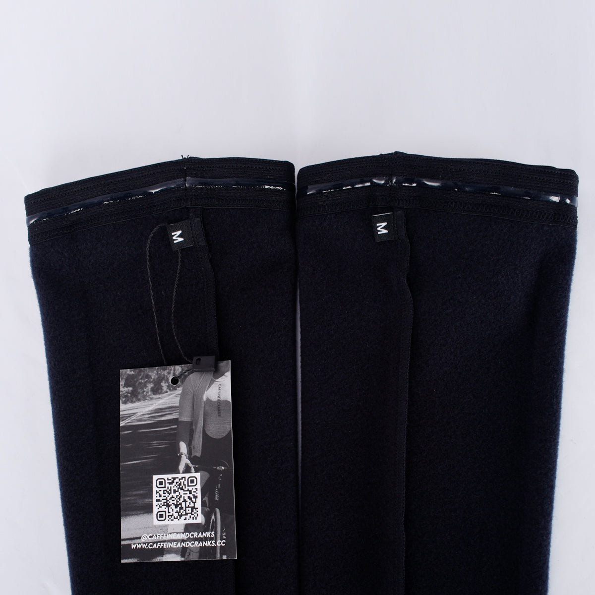 Close up of navy thermal arm warmers, with silicone grip and size M tag.