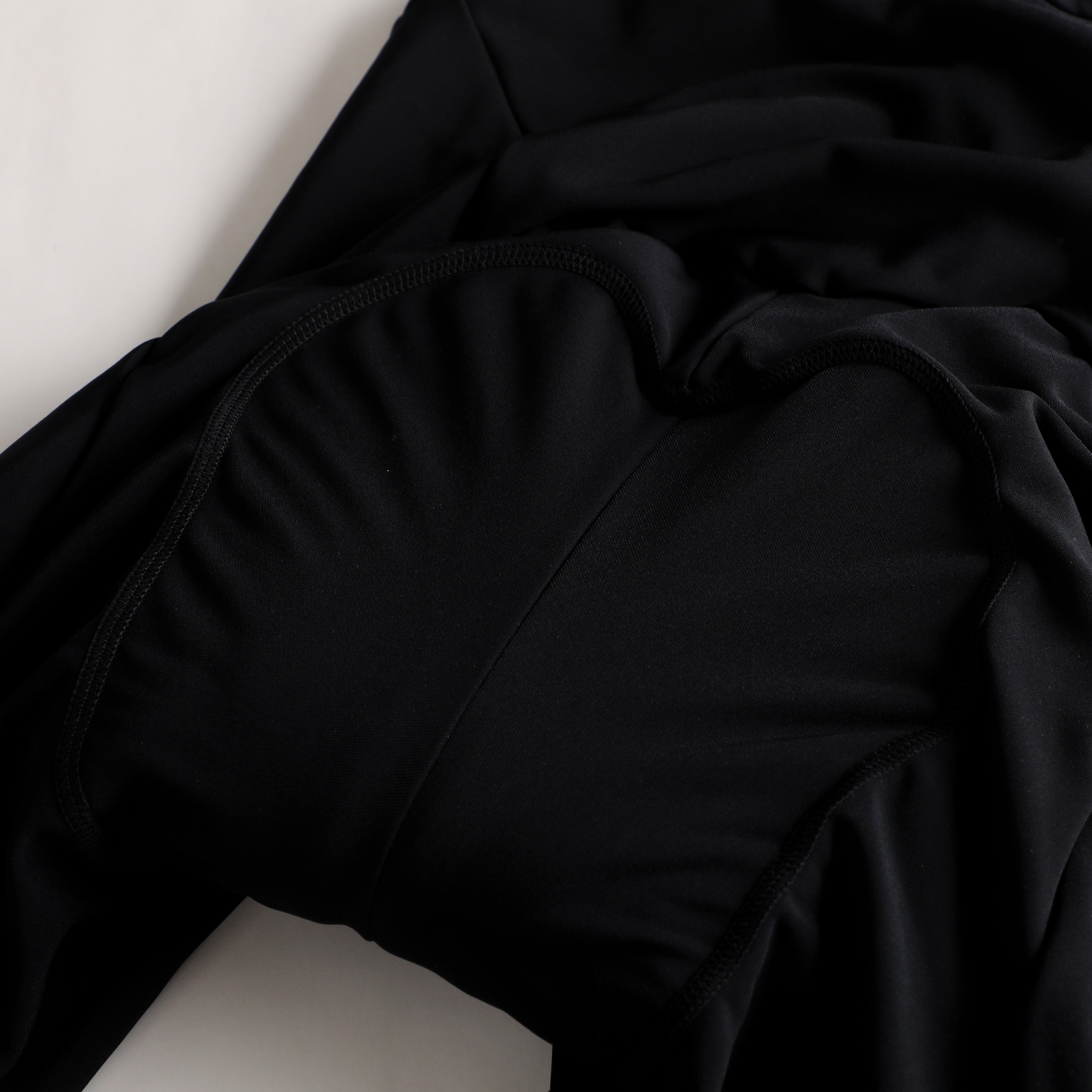 Close up of black thermal bib, showing fabric texture and stitching details.