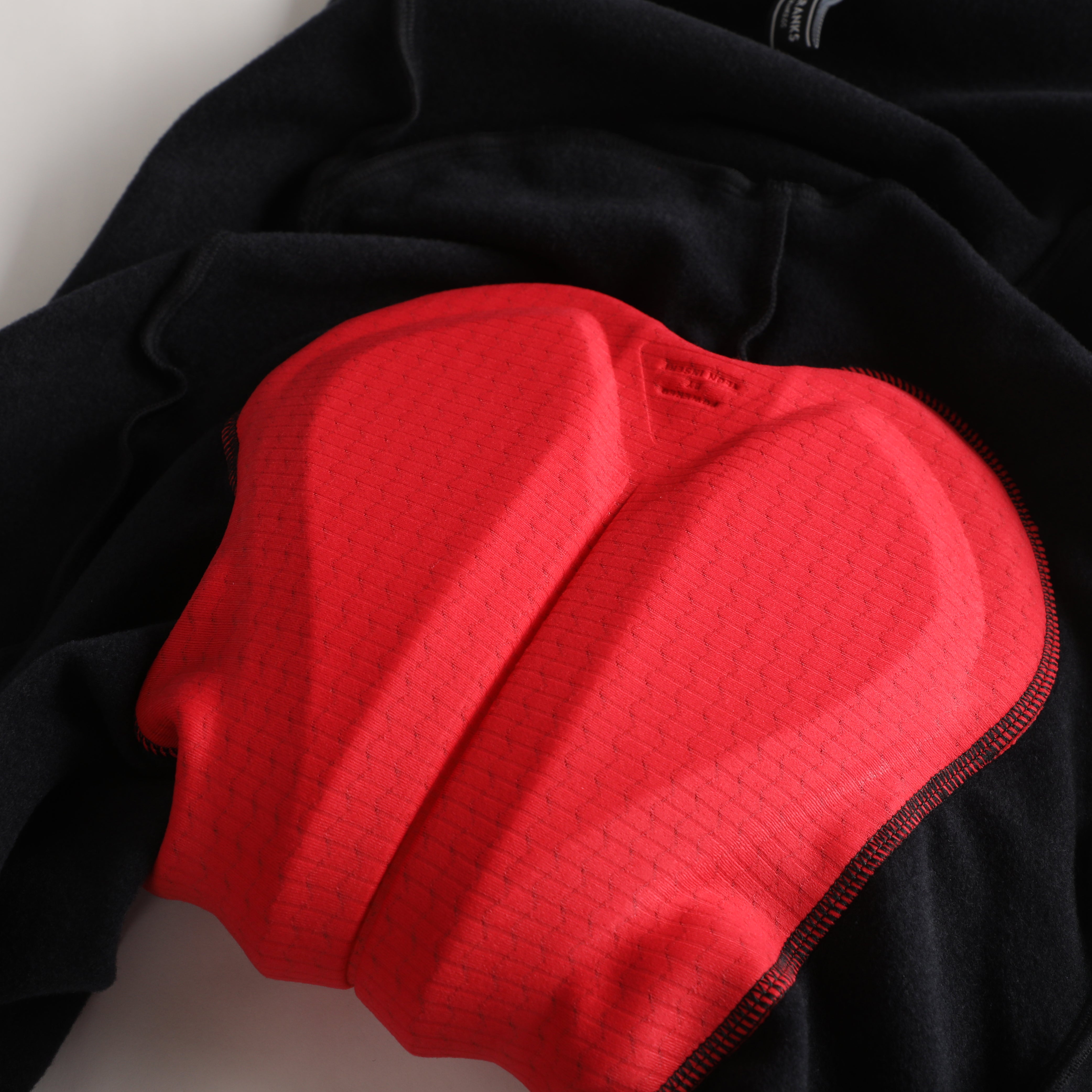 Close-up of black thermal bib shorts with a red padded liner.