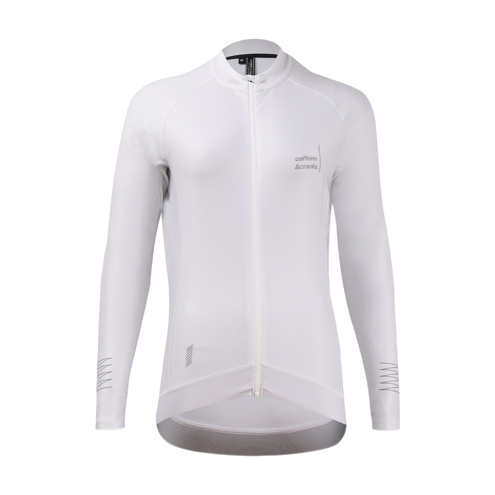White women's long-sleeve cycling jersey with grey 'caffeine & cranks' logo and reflective cuff details.
