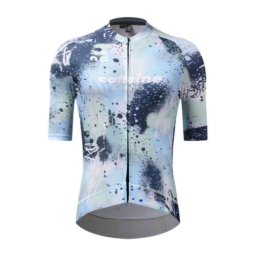 Front view of C&C Overspray Jersey for women, featuring a blue, light green, and white splatter print.