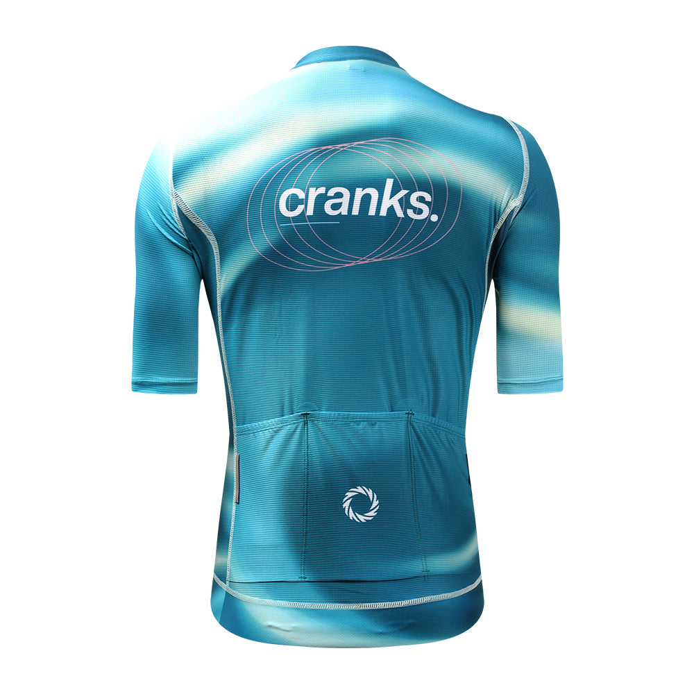 Back view of C&C Flux jersey with teal, light blue, and white abstract design, featuring "cranks." logo on back.