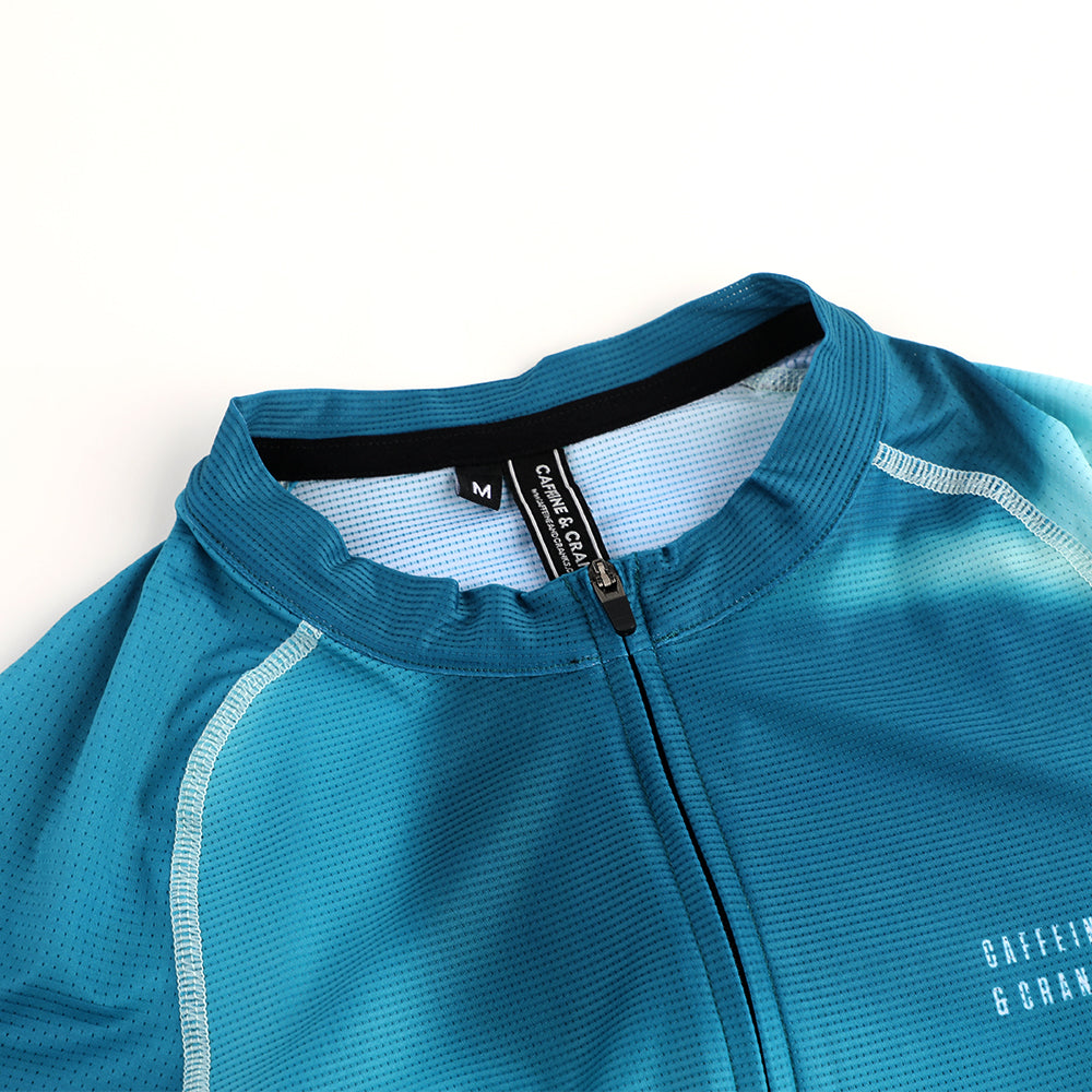 Closeup of C&C Flux Jersey collar showing blue turquoise gradient, white stitching, and zipper.