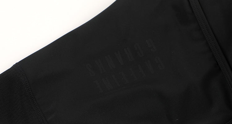 Close-up of black women's bib shorts with subtle embossed logo detail.