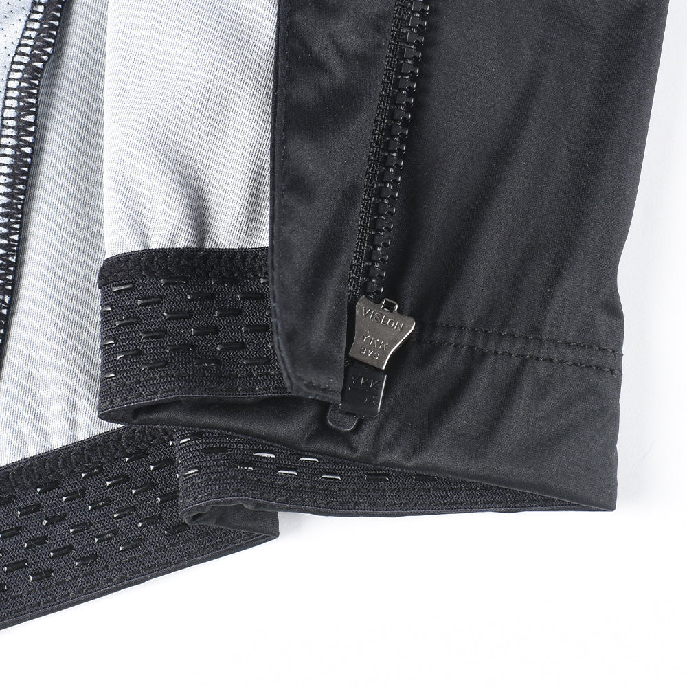 Detail of C&C Core Gilet - Mens in black, showing YKK zipper, black elastic hem with grippy texture.