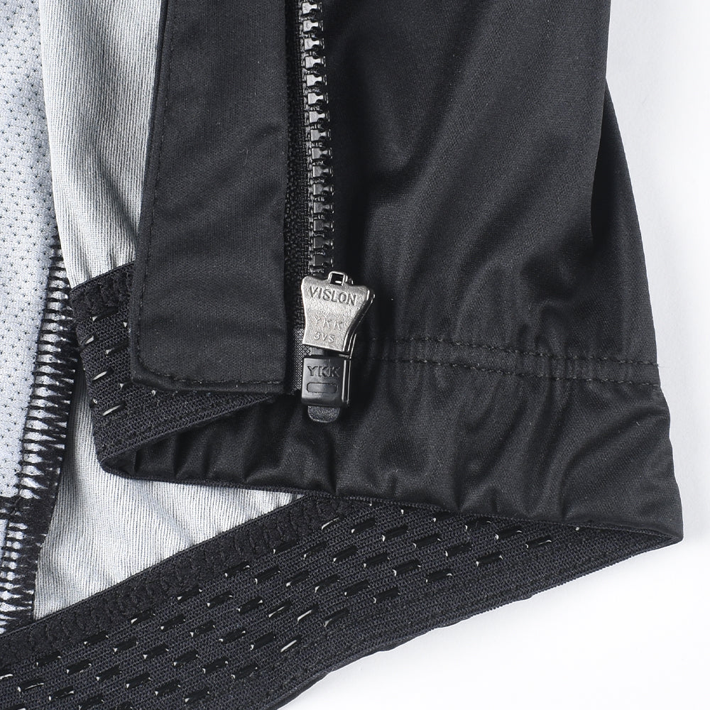 Close-up of C&C Core Gilet - Womens, showing black fabric, YKK zipper, and grey mesh panel.