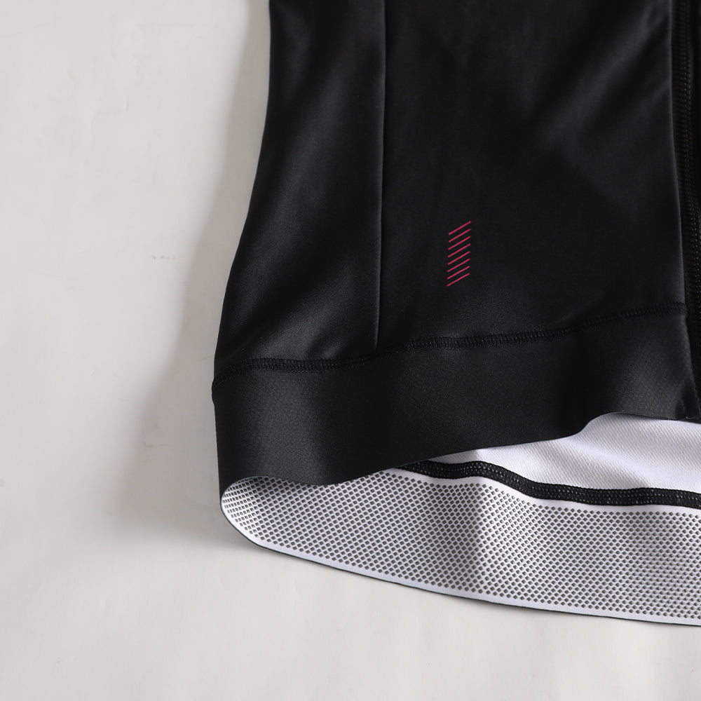 Close-up of black women's thermal jersey with pink accent logo and grippy hem.