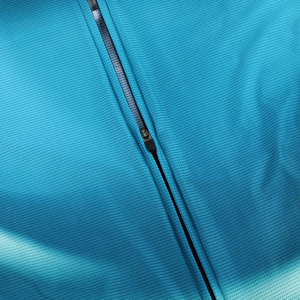 Close-up of blue C&C women's cycling jersey with textured fabric and zippered front.