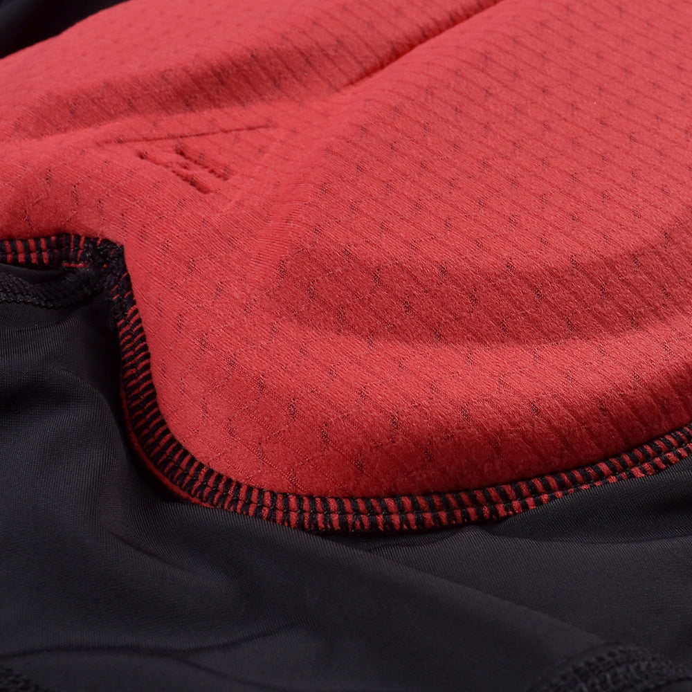 Close-up of padded red chamois with black bib shorts fabric detail.