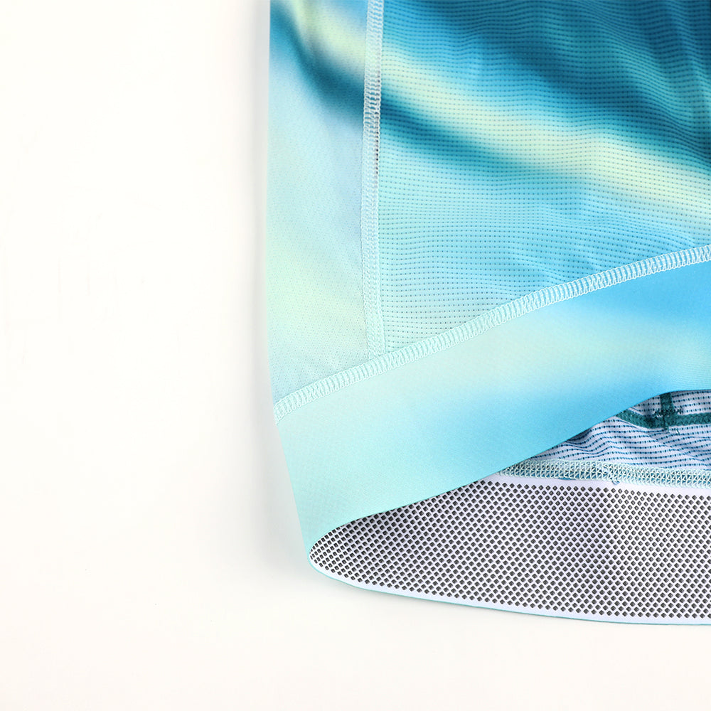 Close-up of C&C Flux Jersey womens cycling shirt hem, with blue/green gradient and grippy stripe.