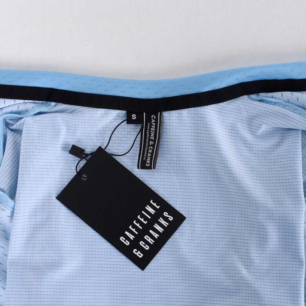 C&C Cerulean Topo Jersey - Womens: Close-up of collar, size S tag, black logo tag, and light blue fabric.