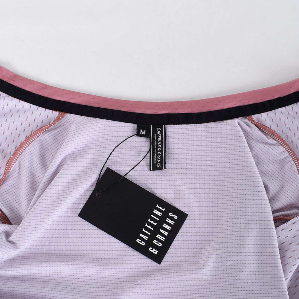 Close-up view of the neck of C&C Garnet Topo Jersey. Light purple with pink trim & black tags.