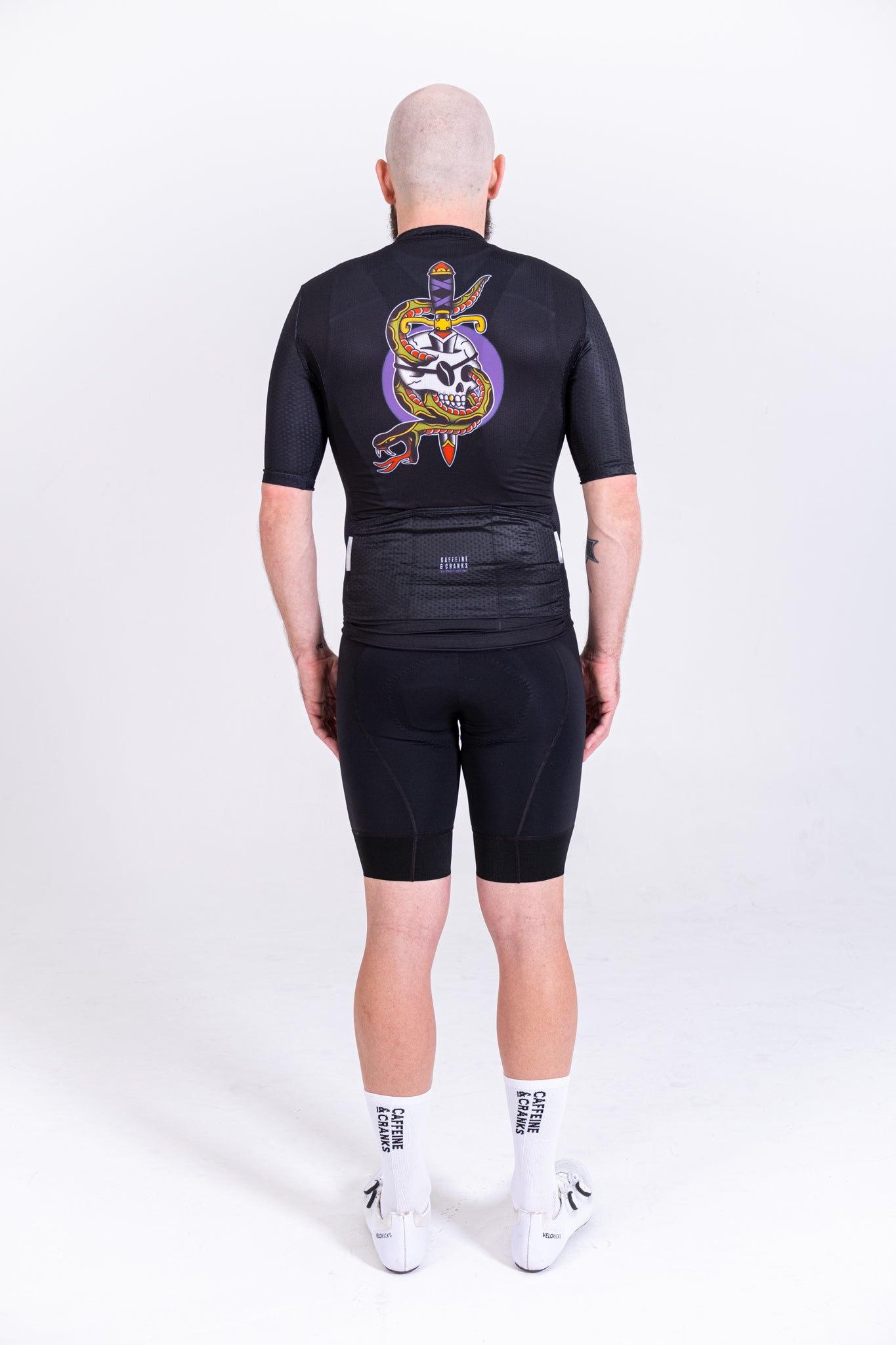 Back view of men's black C&C Tattoo Series jersey with skull & snake design. Purple, yellow, red.
