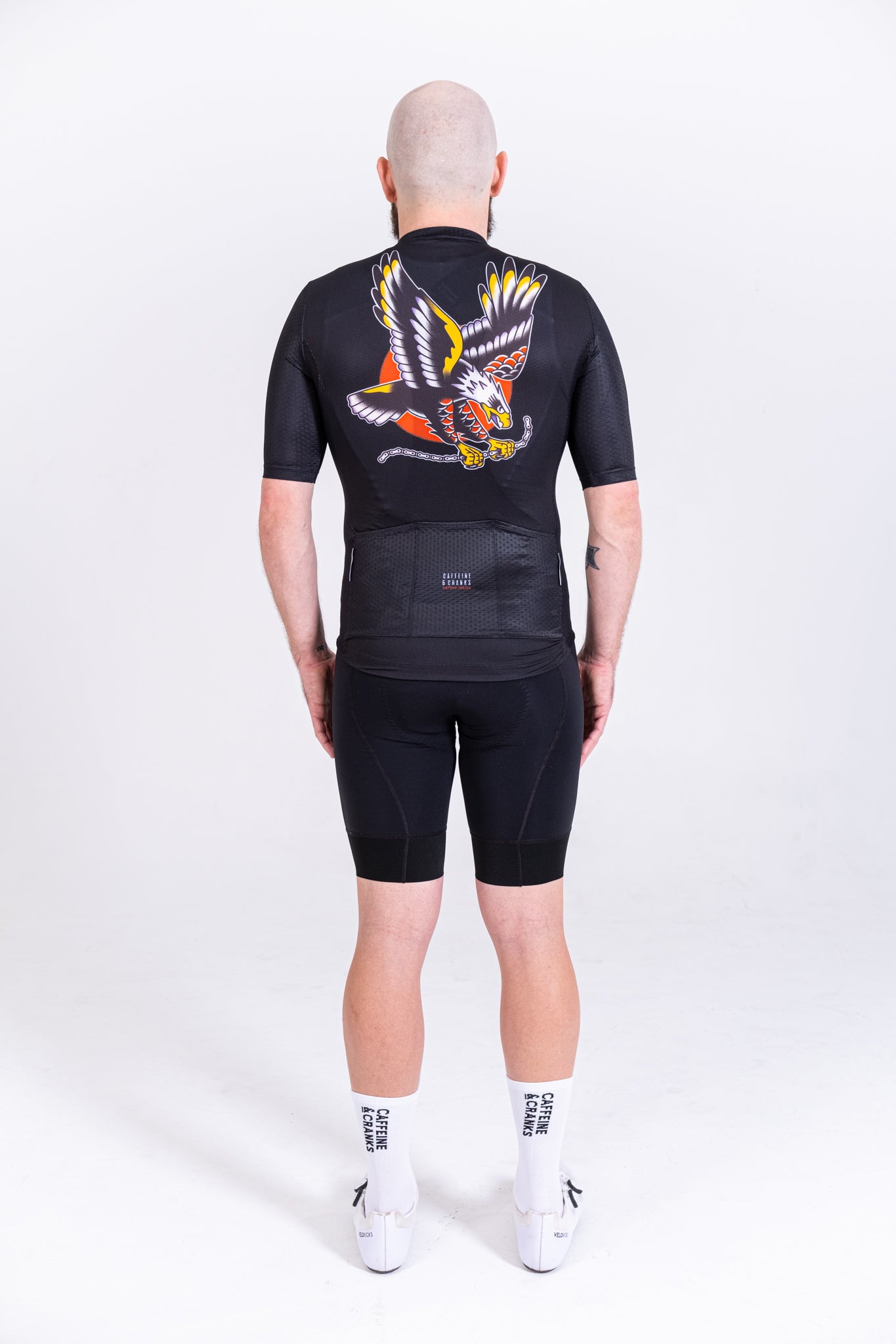 Back view of C&C Tattoo Series Eagle Jersey in black with colorful eagle graphic, paired with black cycling shorts.