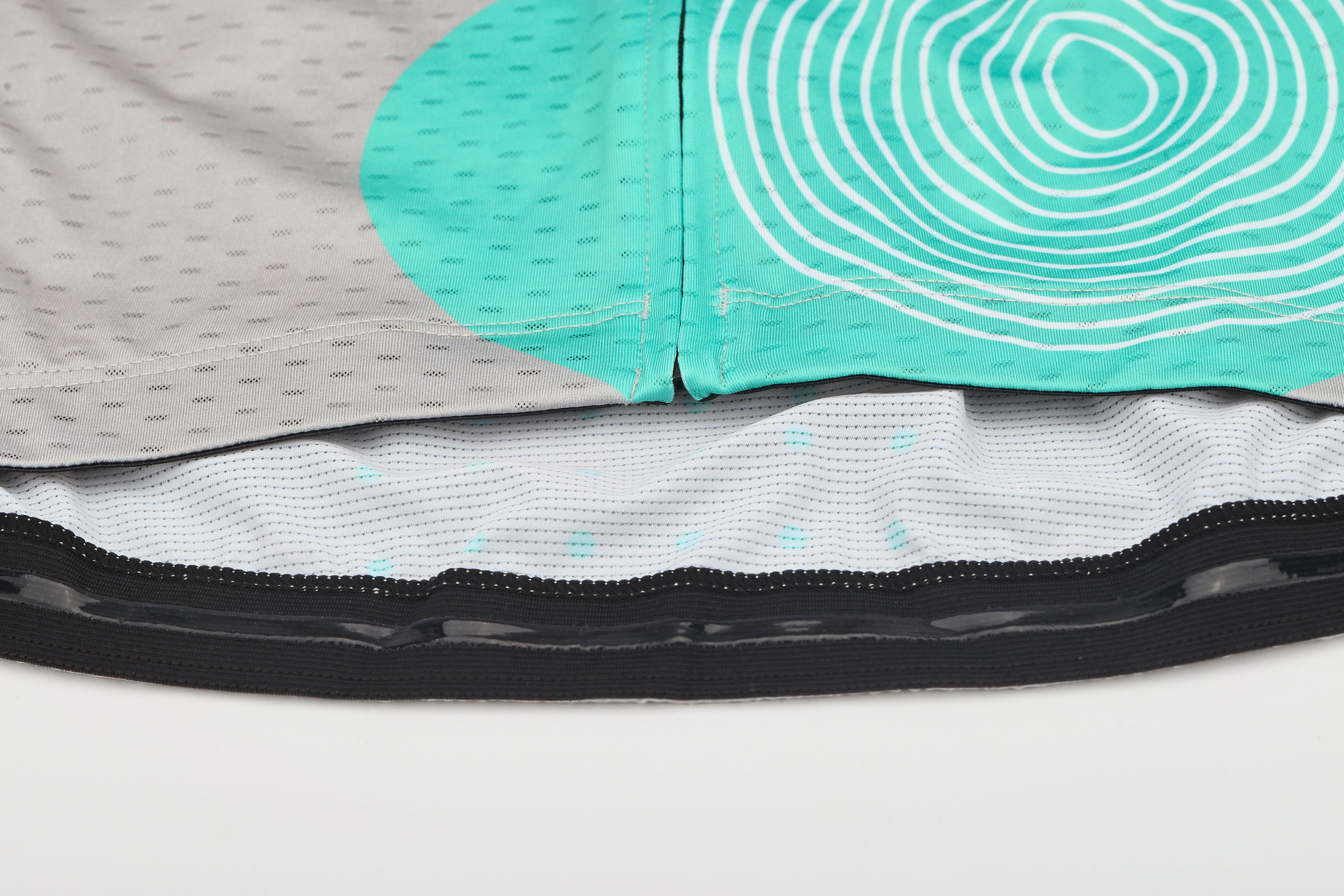 C&C Memphis Women's jersey detail: grey with teal circles, white wavy lines, black elastic hem.