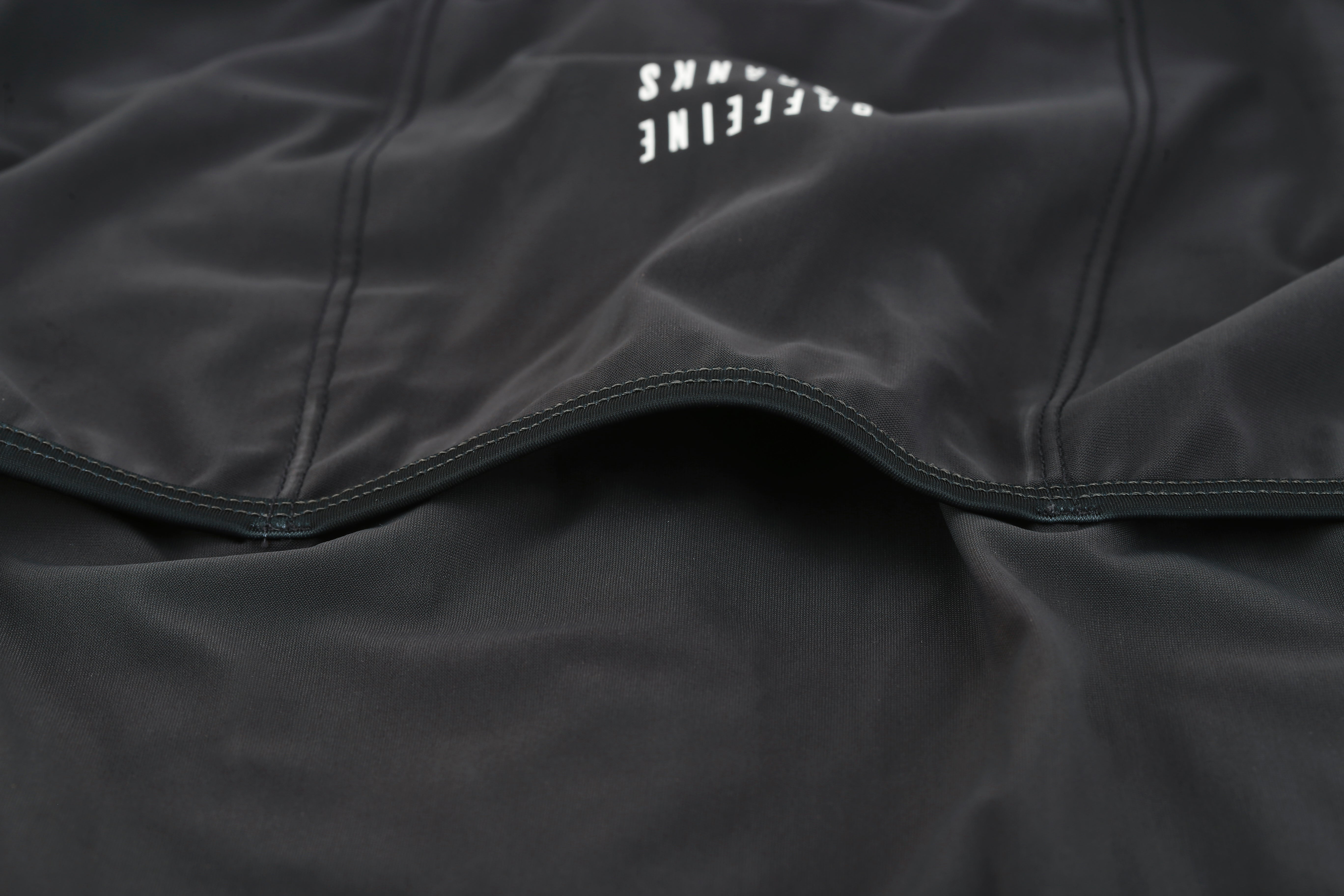 Close-up of men's Pinnacle jersey in slate gray, showing textured fabric and white logo detail.