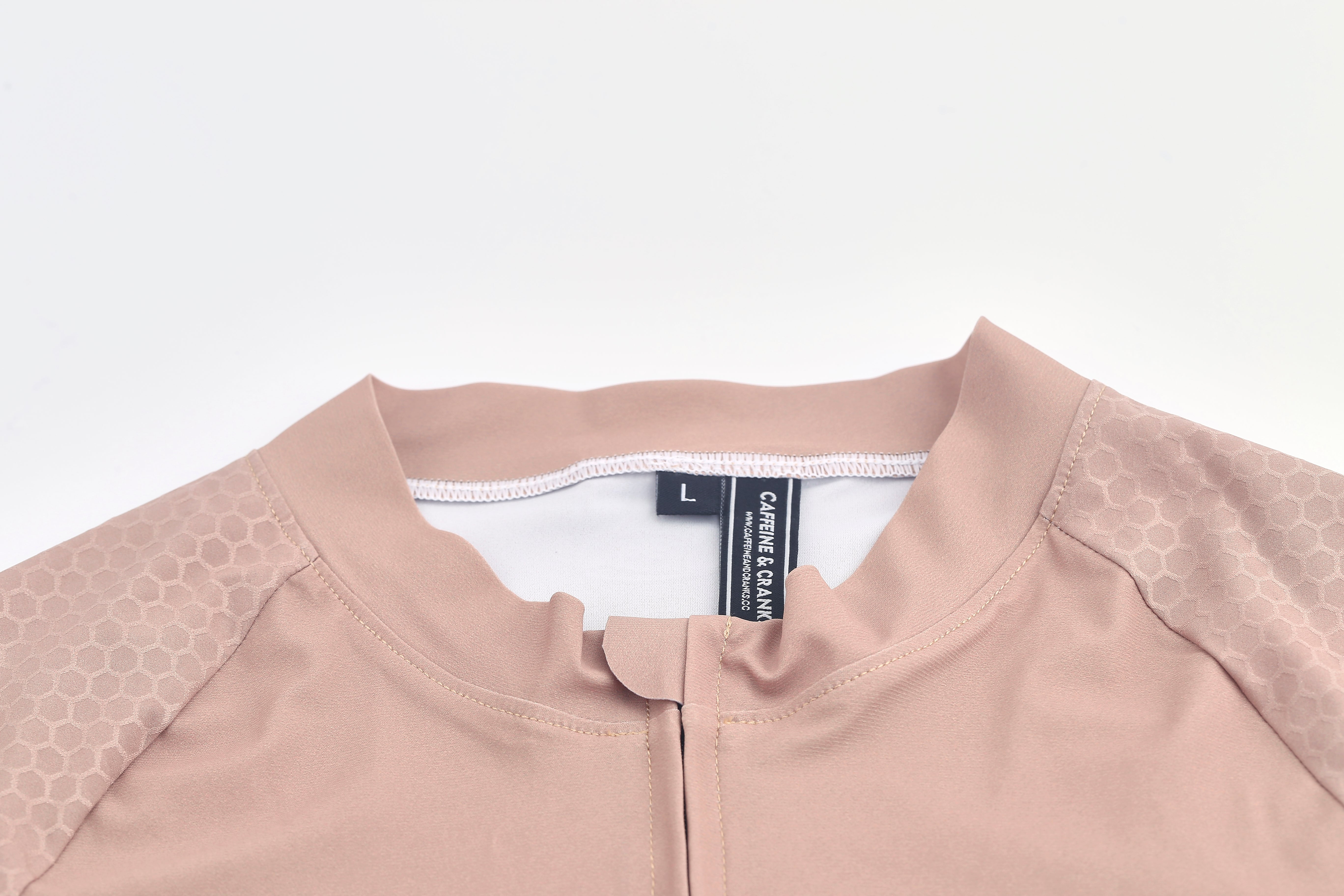 Close-up of women's clay-colored Pinnacle jersey with honeycomb sleeve detail