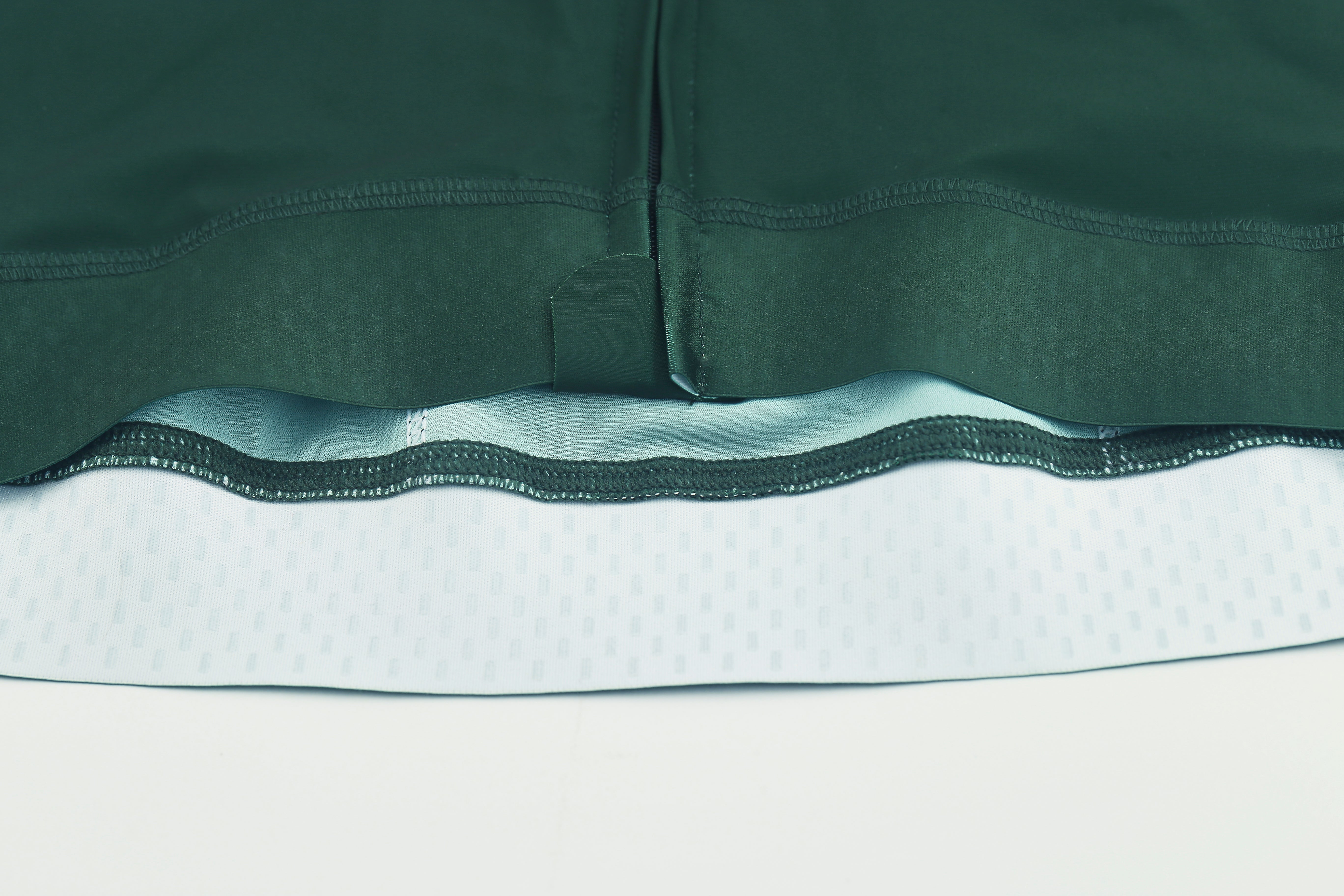 Pinnacle Jersey detail: forest green exterior, light blue patterned interior, zipper bottom view.