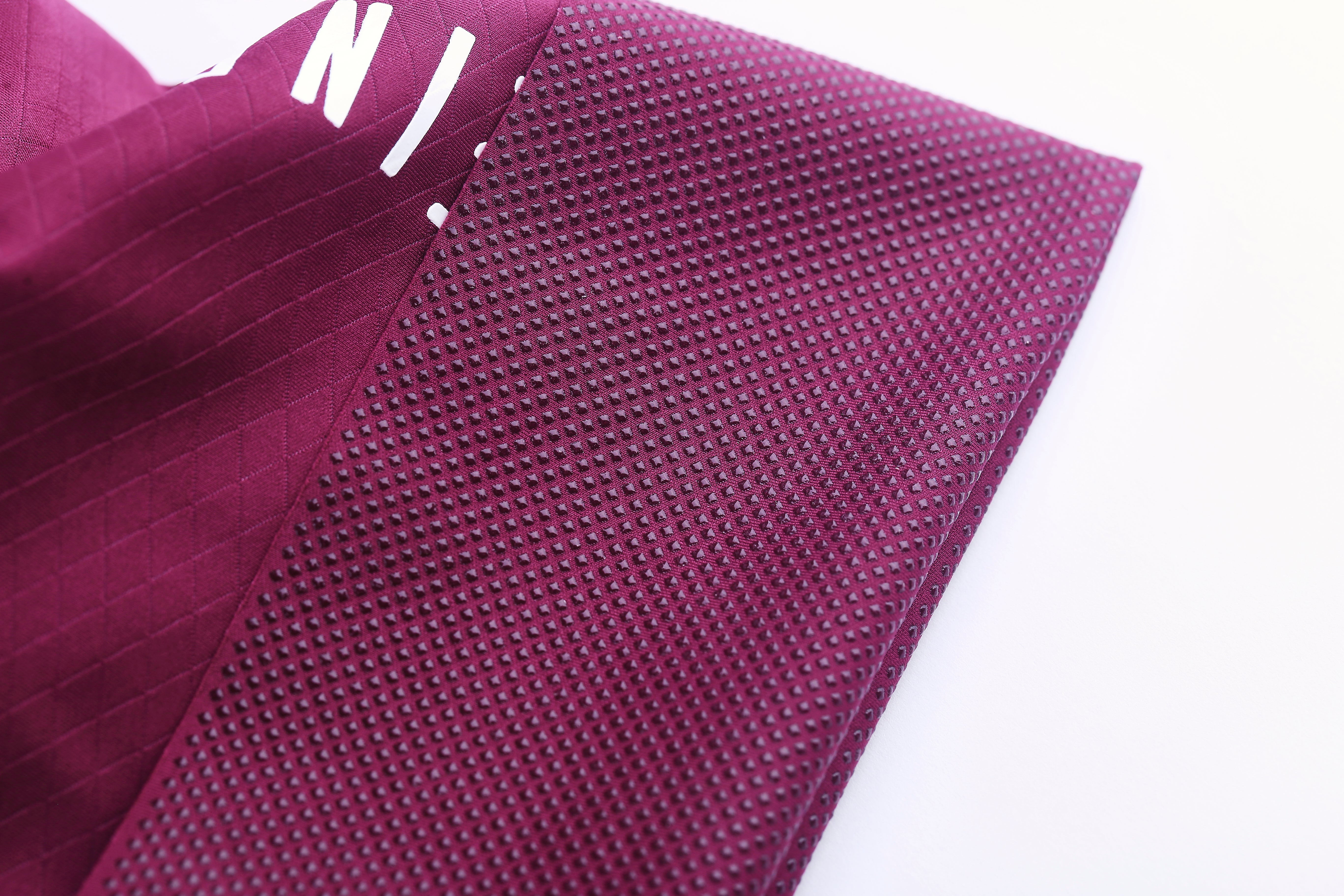 Close-up of royal bib shorts, showing textured diamond grip pattern in deep purple.
