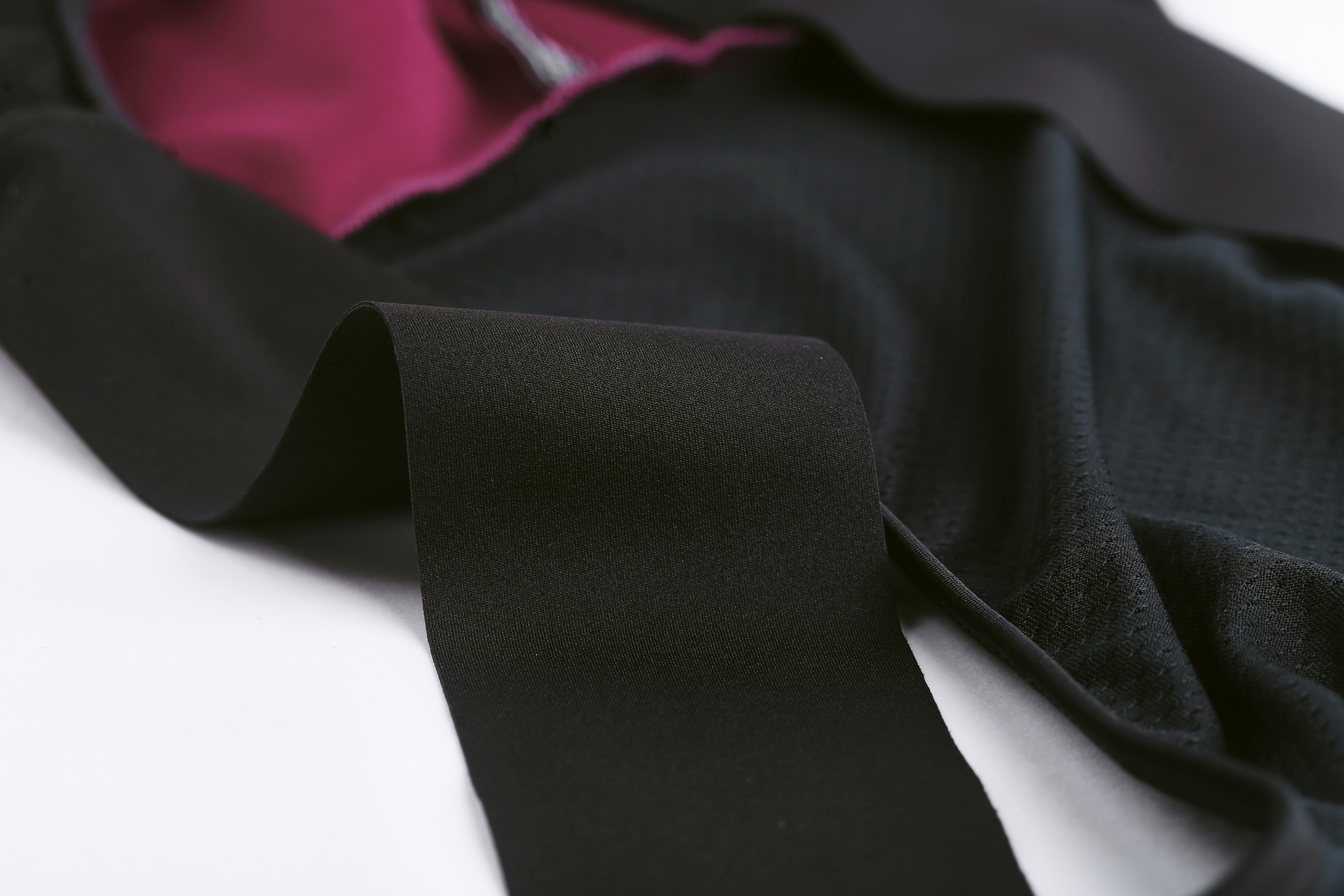 Close-up of black Pinnacle bib shorts with visible pink lining and elasticated straps.