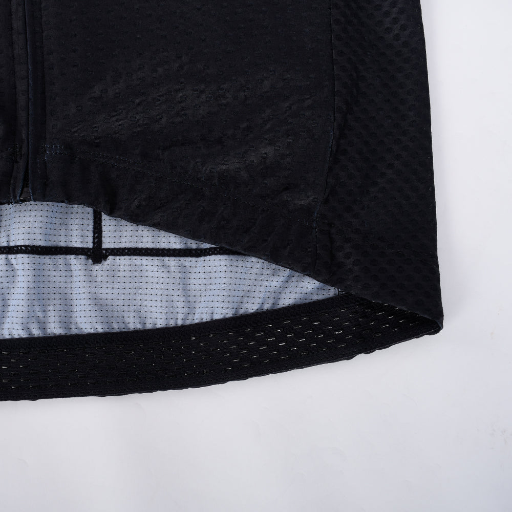 Close-up of black C&C Tattoo Series mens jersey hem. Perforated black cuffs & mesh.