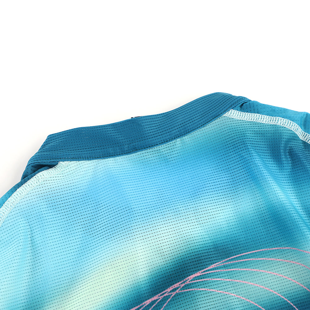 Close-up of C&C Flux Jersey neckline, women's, teal blue gradient, mesh fabric, pink accents.