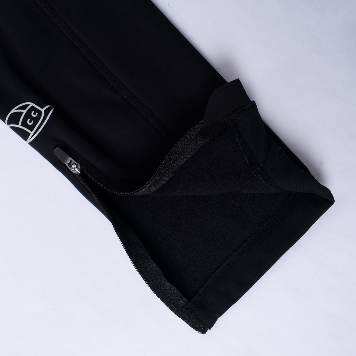 Black thermal leg warmers with fleece lining and zipper cuff.