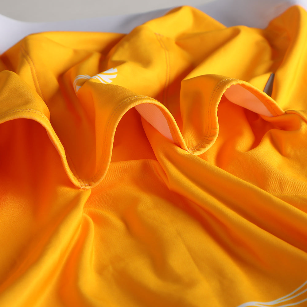 Close up of Pinnacle Thermal Jersey in solarflare orange, showing fabric texture & seams.