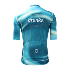 Back view of C&C Flux jersey with teal, light blue, and white abstract design, featuring "cranks." logo on back.