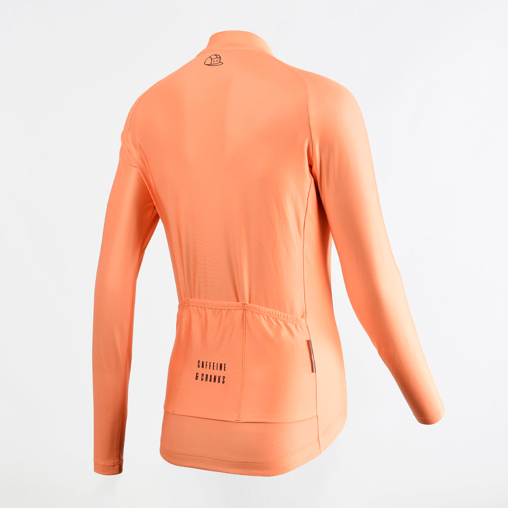 Back view of women's orange long-sleeve thermal cycling jersey with 3 rear pockets, black logo.