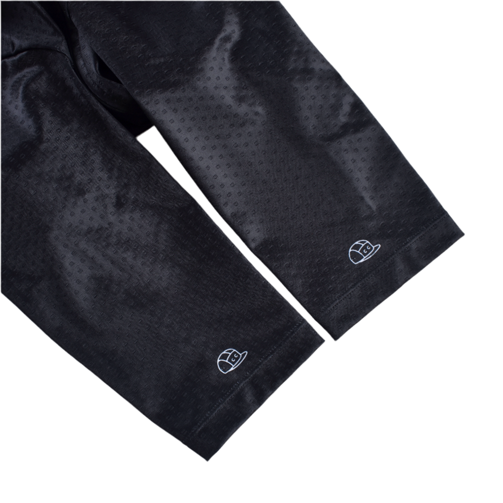 Close-up of C&C Bonk Club Jersey sleeves in dark with textured pattern & white embroidered logo.
