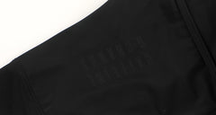 Close-up of black women's bib shorts with subtle embossed logo detail.