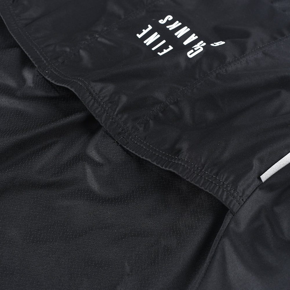 Close-up of black C&C Core Gilet for women, showing textured material & white "Fine Cranks" logo.