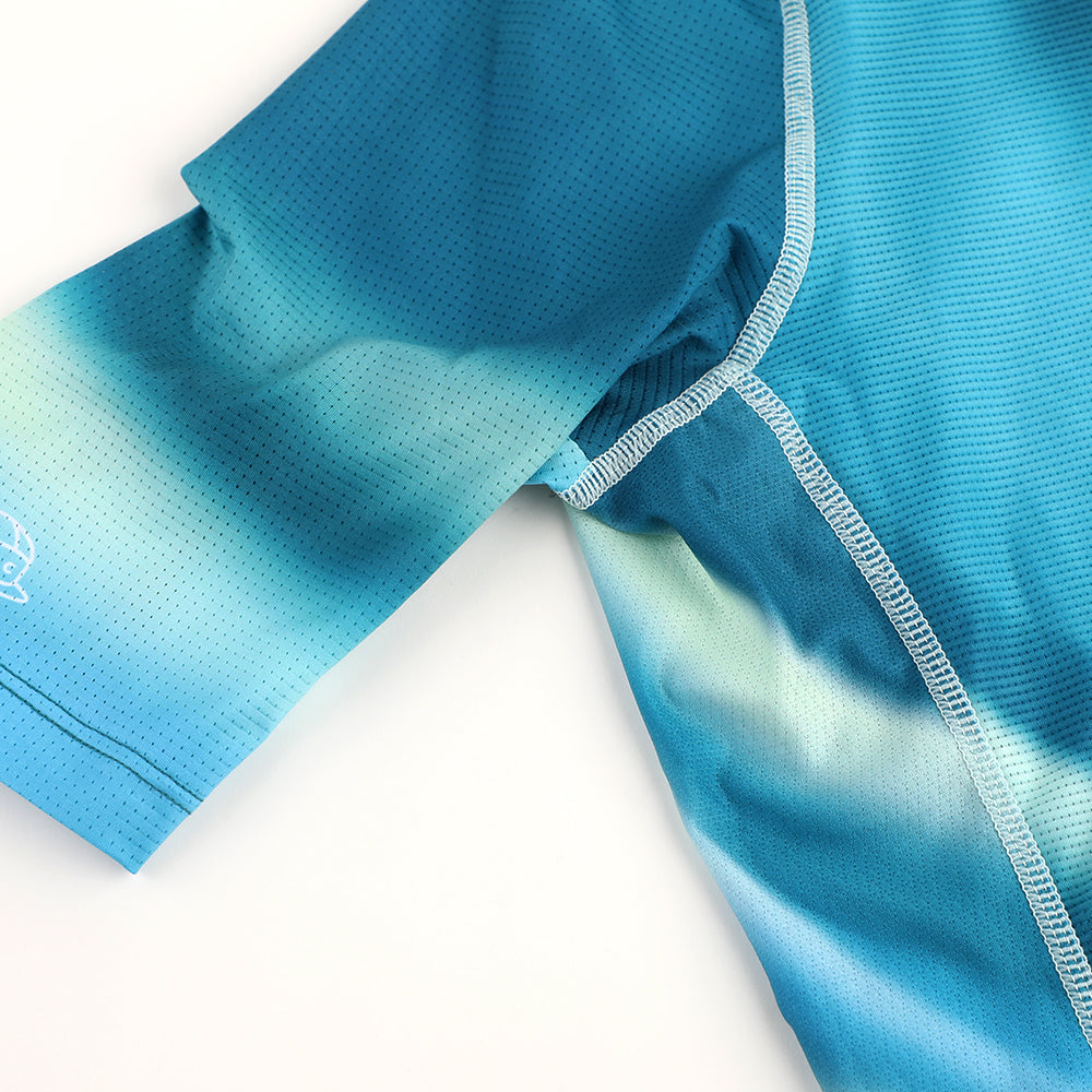Close up of C&C Flux Jersey sleeve and shoulder in blue & green gradient, perforated fabric.