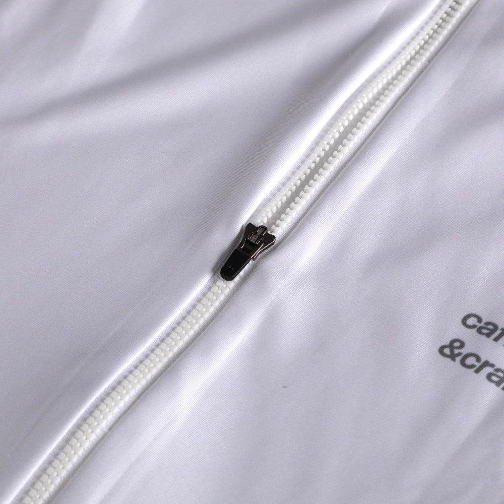 Close-up of white Pinnacle Thermal Jersey showing a white zipper with black pull tab.