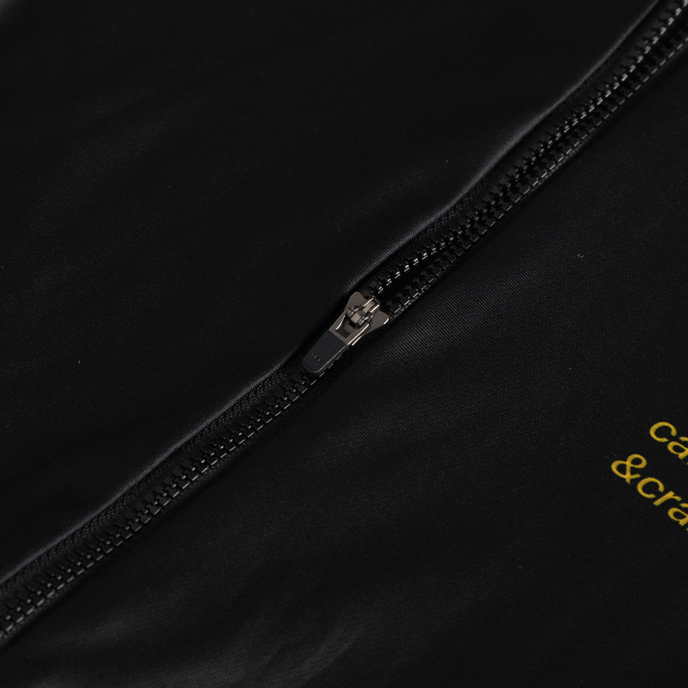 Close-up of black Pinnacle thermal jersey with a silver zipper and yellow text detail.