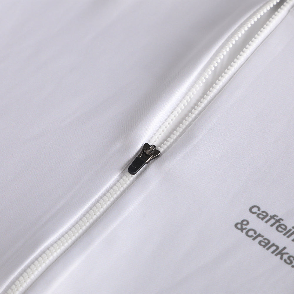 Close-up of the white Pinnacle Thermal Jersey's white zipper with dark pull tab. Grey logo visible.
