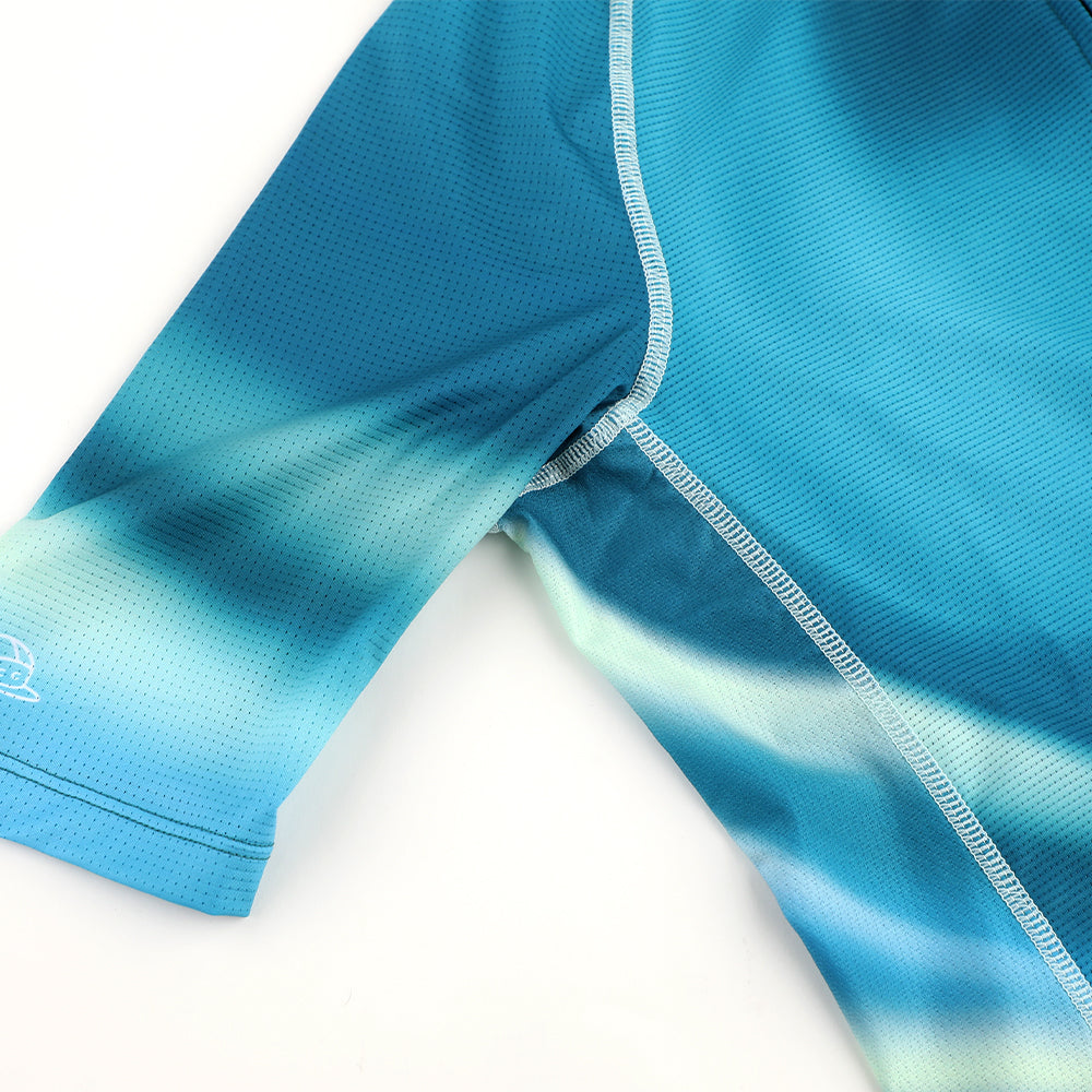 Close-up of C&C Flux Jersey, sleeve and torso. Blue & teal ombre graphic, breathable mesh fabric.