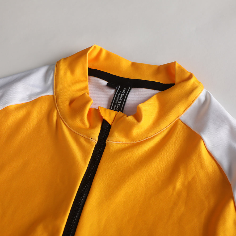 Close-up of Pinnacle Thermal Jersey: Solarflare yellow with white sleeves, black zipper and collar trim.