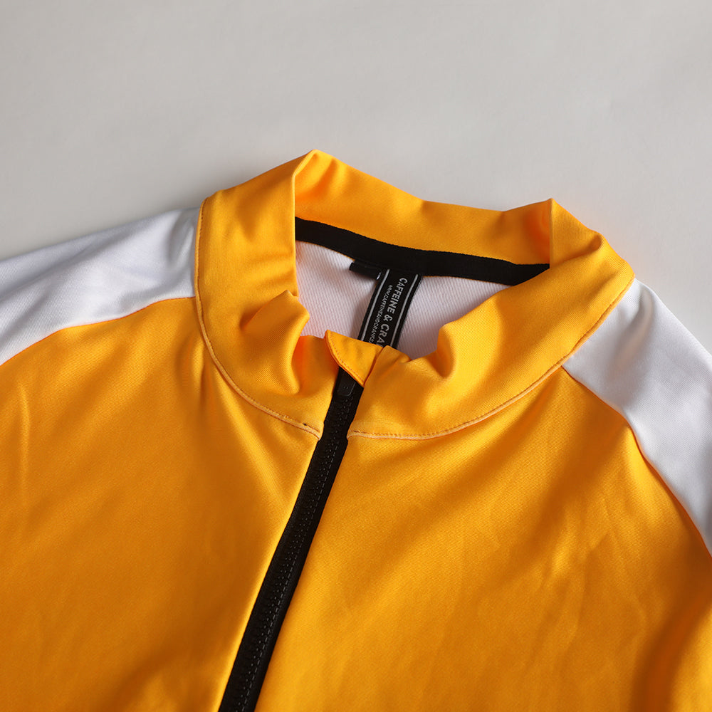 Close-up of the women's Pinnacle Thermal Jersey in solarflare yellow with white sleeves and black zipper.