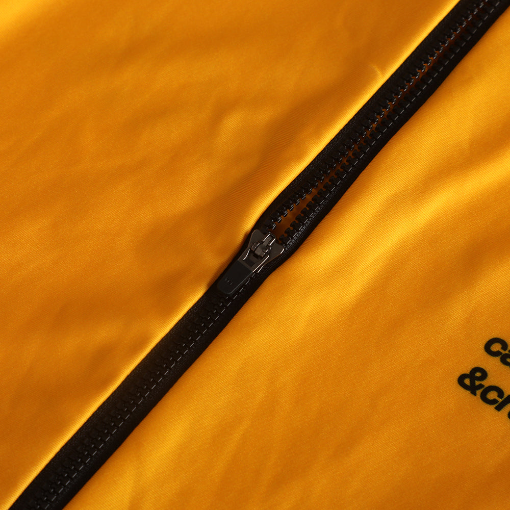 Close-up of men's yellow Pinnacle Thermal Jersey with a black zipper and subtle black text on the side.
