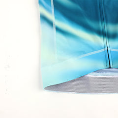 Right side view of C&C Flux Jersey, blue, green, and yellow gradient, zipper details. Grid hem.