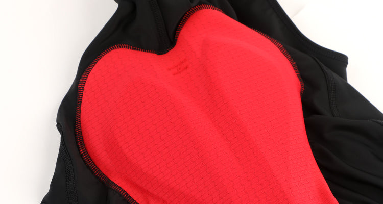 Close-up of women's black cargo bib shorts with a bright red padded insert and red stitching.
