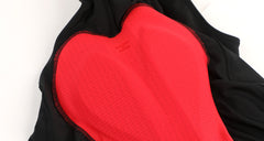 Close-up of women's black cargo bib shorts with a bright red padded insert and red stitching.