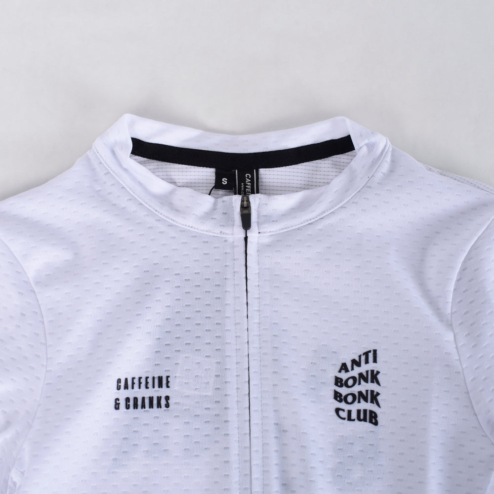 Close up of a white C&C Bonk Club jersey. Features black text and a black zip.