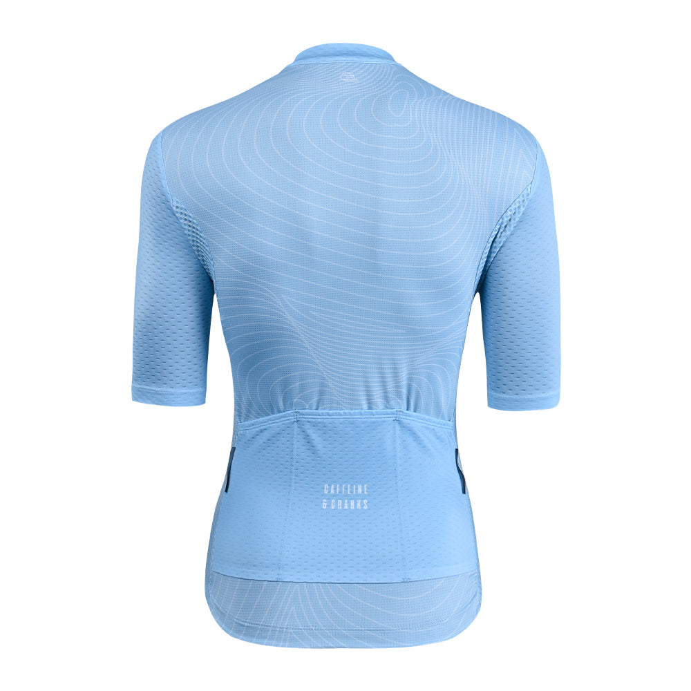 Back view of a women's light blue C&C cycling jersey with a white topographic pattern.