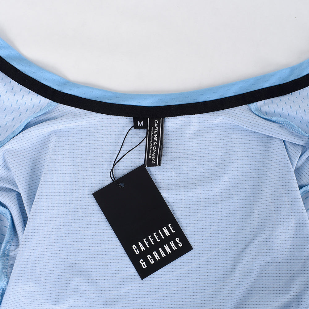 Close-up of C&C Cerulean Topo Jersey collar & tag, light blue topo print, black accents.