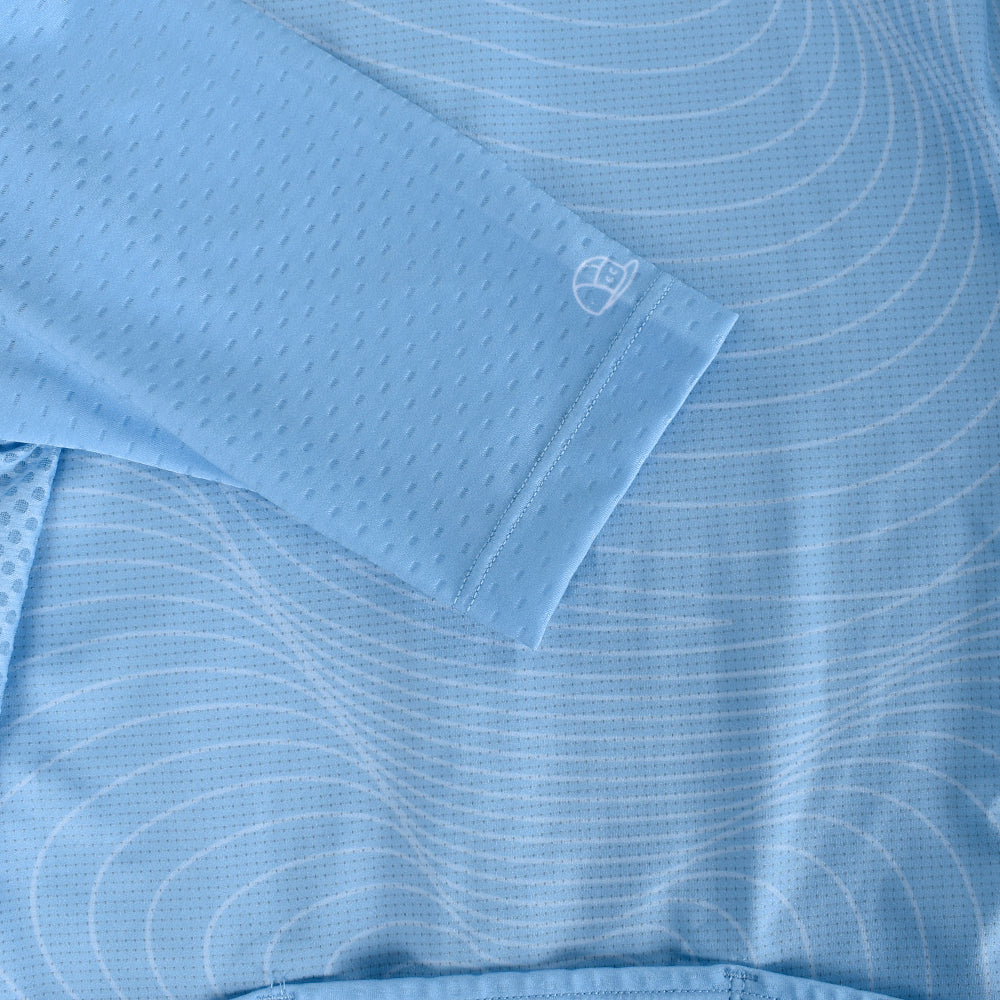 Close-up of a light blue womens C&C jersey with white topo pattern and embroidered logo.